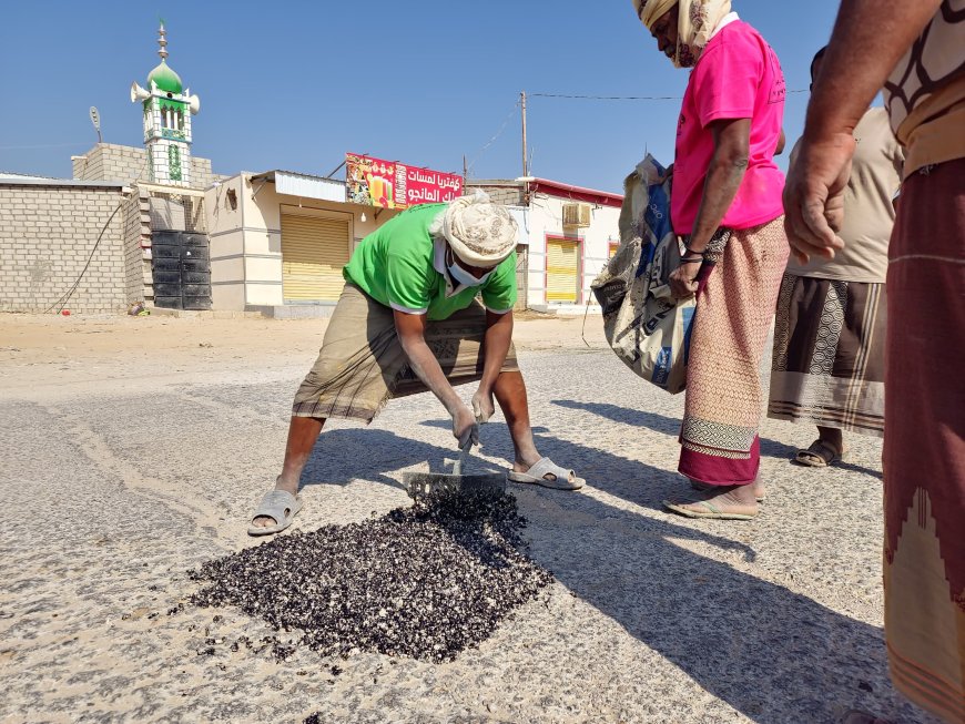 فريق الصيانة بمكتب الاشغال العامة والطرق بمديرية القطن يقوم بأعمال ردم الحفر في الاسفلت داخل المدينة و السوق التجاري